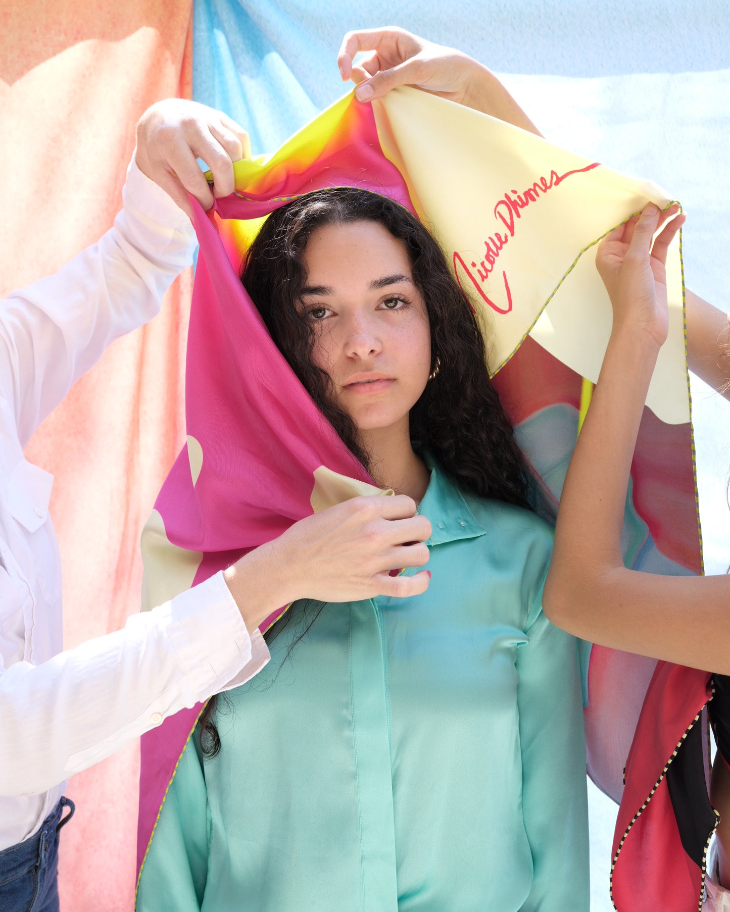 models show off a pink and yellow silk scarf