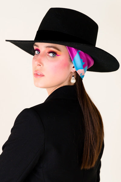 model styled with silk scarf under a hat 