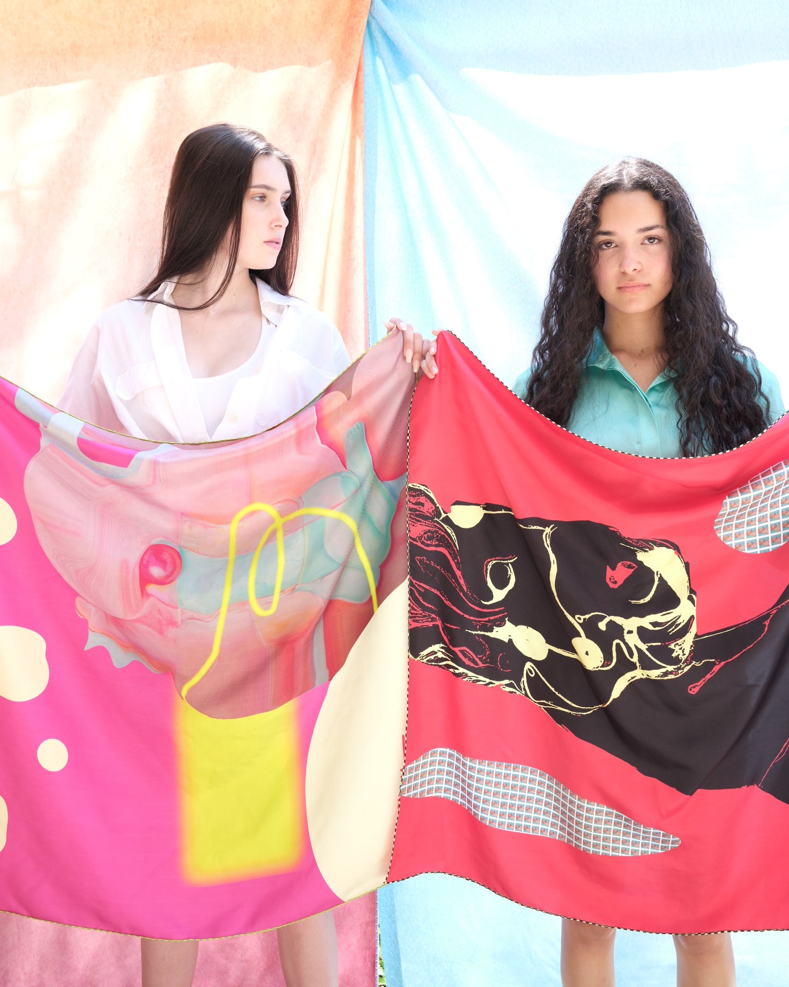 girls holding silk scarves with equastrian  design in bright bold colors. 